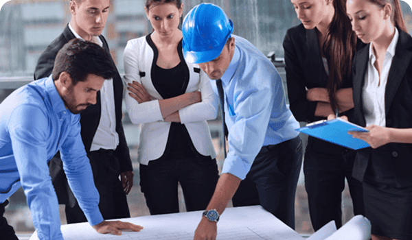 Profesionales analizando planos en una empresa en fase de proyecto, parte de los sectores atendidos por O&S Consultores.